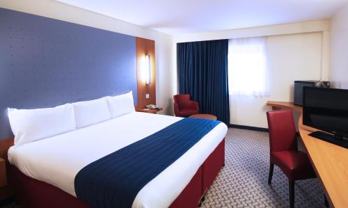 a hotel room with a bed and a television at Ramada London North in Barnet