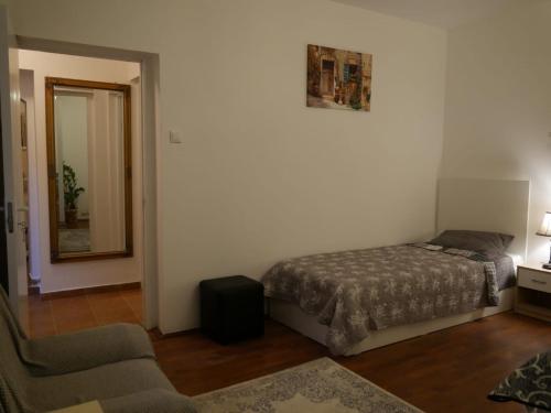ein Schlafzimmer mit einem Bett, einem Stuhl und einem Spiegel in der Unterkunft Jolie Place Old Town in Timişoara
