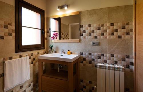 a bathroom with a sink and a mirror at Apartamentos Vega Rodiles el balcón in Villaviciosa