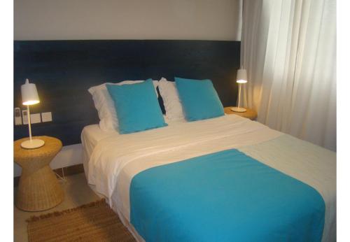 - un lit bleu et blanc dans une chambre avec deux lampes dans l'établissement Althea's stylish,homely apartment on the beach by Althea Holidays - AH 7, à Grand Baie