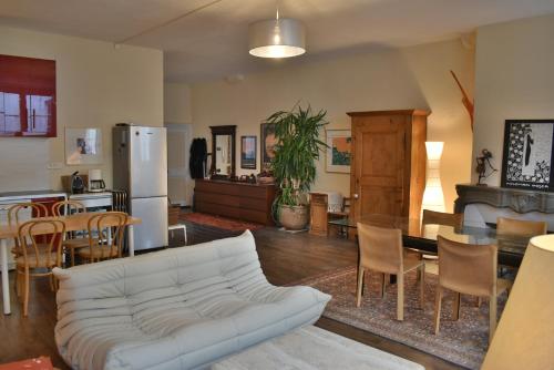 a living room with a white couch and a kitchen at La Bisontine in Besançon