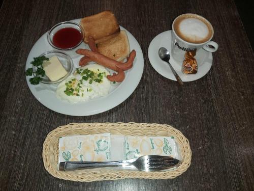 - une table avec deux assiettes de nourriture et une tasse de café dans l'établissement Geltona, à Šiauliai