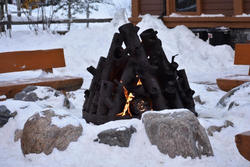 a fireplace with a fire in the snow at The Viking Lodge - Downtown Winter Park Colorado in Winter Park