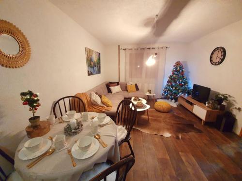 a living room with a table and a christmas tree at Vikend Kuća Iman in Vlasic