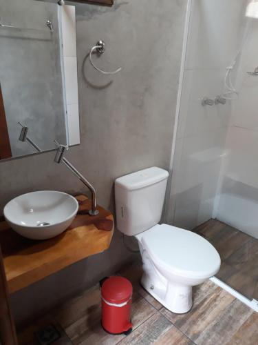 a bathroom with a white toilet and a sink at Solar dos Pinhais in Santo Antônio do Pinhal