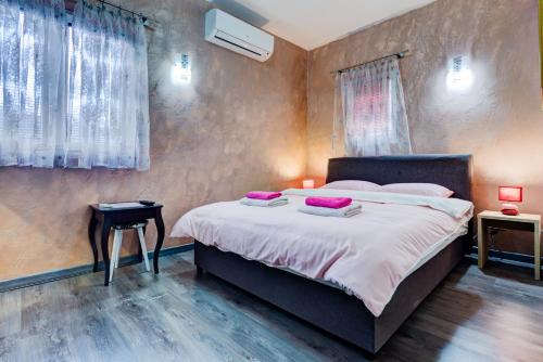 a bedroom with a large bed with purple pillows on it at Castelomi in Podgorica