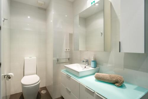 La salle de bains blanche est pourvue d'un lavabo et de toilettes. dans l'établissement PACIFICO Family Home by Cadiz4Rentals, à Cadix