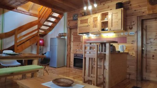 eine Küche mit Holzwänden und eine Treppe in einer Hütte in der Unterkunft Apartments Life in Kolašin