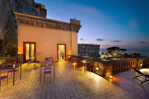 a patio with tables and chairs on a balcony at Marina Piccola 73 in Sorrento