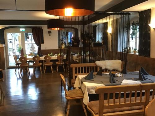 ein Restaurant mit Tischen und Stühlen und ein Esszimmer in der Unterkunft Landhaus Krone in Steinach