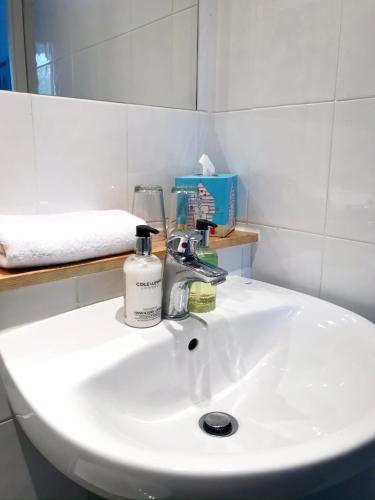 a bathroom sink with a bottle of soap on it at Seabreeze Restaurant With Rooms in Aberdyfi