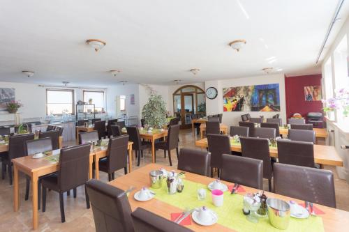 un comedor con mesas y sillas y una cafetería en Hotel Bartholomäus, en Zeitlarn