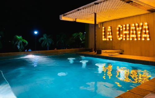 a swimming pool in front of a building at night at Hotel Petén Express in Flores