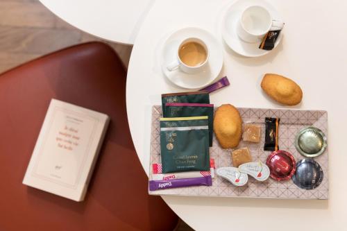 a table topped with a cup of coffee and a book at MiHotel Bizolon in Lyon