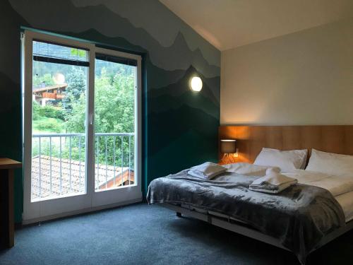 a bedroom with a bed and a large window at Ibex Lodge in Sankt Anton am Arlberg