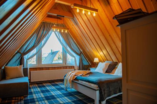 a bedroom with a bed and a large window at Apartamenty Miluchna in Zakopane