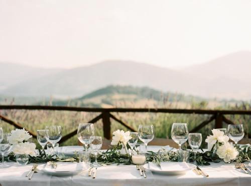 a table with wine glasses and white flowers on it at Nikis Resort in Gubbio