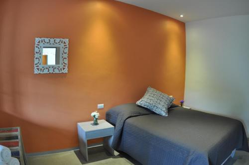a bedroom with a bed and a mirror on the wall at La Betulia Bed and Breakfast in Oaxaca City