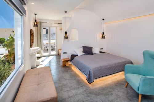 1 dormitorio con 1 cama y 1 silla azul en Gianna Suites, en Fira