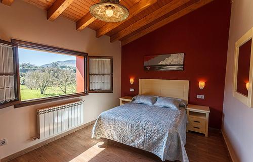sypialnia z łóżkiem i dużym oknem w obiekcie Apartamentos Vega Rodiles el campu w mieście Villaviciosa