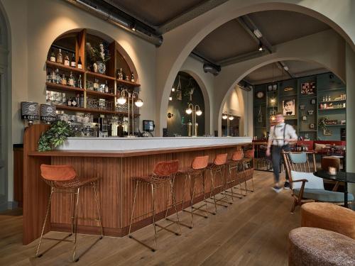 een persoon aan een bar in een restaurant bij FINCH Boutique Hotel, downtown in Deventer