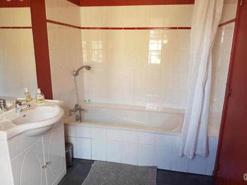 a bathroom with a tub and a sink and a bath tub at le patio de l'oustal in Gimont