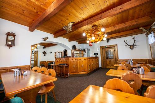 a restaurant with wooden tables and chairs and a clock at Hotel Svaty Hubert in Boží Dar