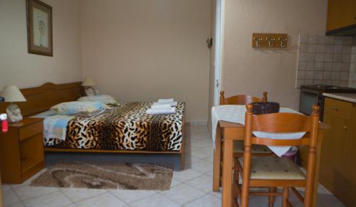 a bedroom with a bed and a table and chairs at Avgi in Kato Loutraki