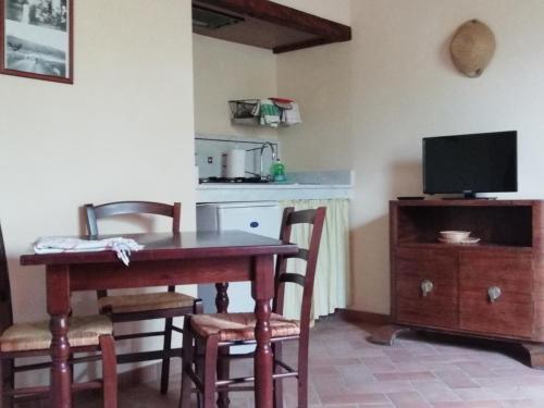 a dining room with a table and chairs and a television at Agriturismo Lupo Vecchio in Grosseto