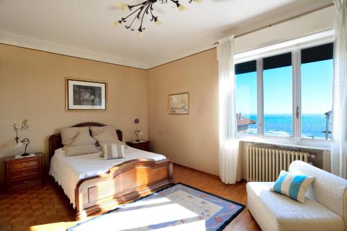 a bedroom with a bed and a couch and windows at Villa Sole in Imperia