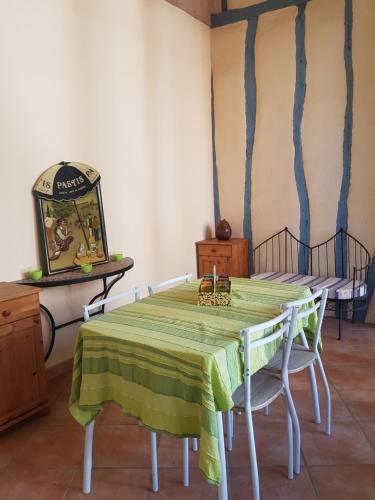 a dining room with a green table and chairs at le patio de l'oustal in Gimont