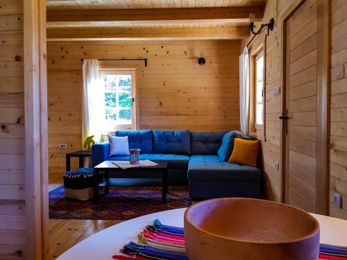 a living room with a blue couch and a table at Holiday Home Milica in Kolašin