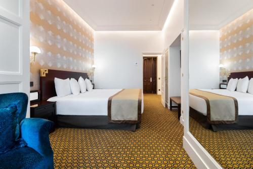 a hotel room with two beds and a chair at Eurostars Gran Hotel La Toja in Isla de la Toja