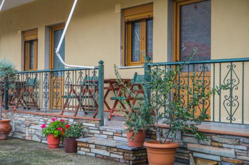 a house with potted plants on the front porch at Avgi in Kato Loutraki