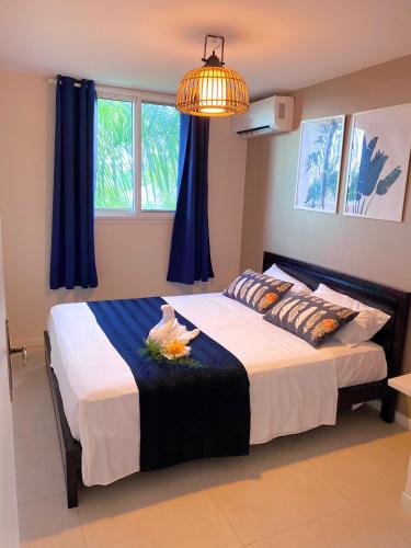a bedroom with a large bed with blue curtains at Résidence Nakiya in Sainte-Marie