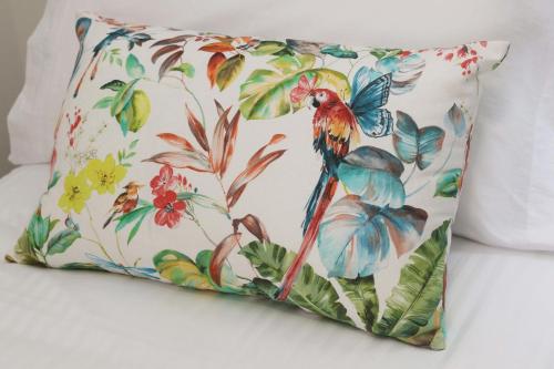 a pillow with a bird on a floral background at Casinhas de Medros in Barcelos