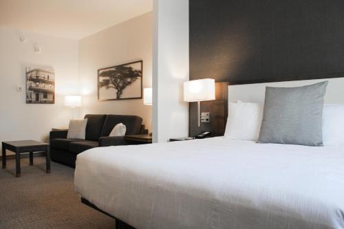 a hotel room with a large bed and a couch at Best Western Plus Morden in Morden