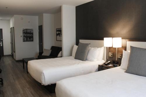 a hotel room with two beds and a chair at Best Western Plus Morden in Morden