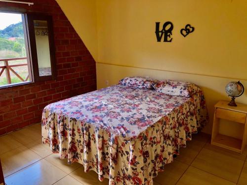 a bedroom with a bed in a room with a window at Chalé Bela Vista - Chalés Belo Monte in Pacoti