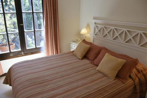 a bedroom with a large bed with brown pillows at Apart Hotel Las Hadas Carilo in Carilo