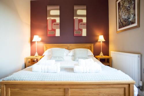 a bedroom with a large white bed with two lamps at The Old Dairy - Brosterfield Farm in Eyam