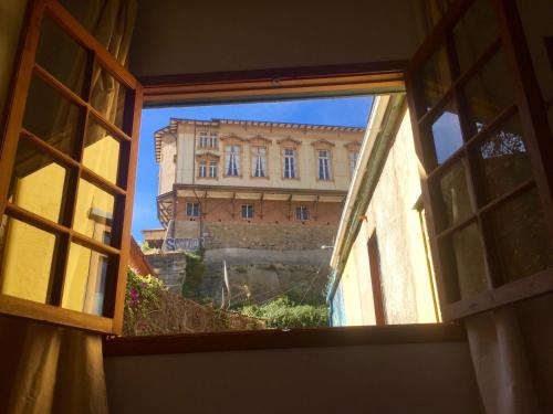 a view of a building from an open window at Casa California Guesthouse in Valparaíso