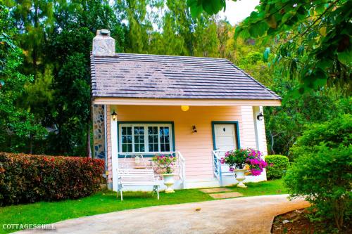 a small house with a bench in a yard at Cottages @ Hill Resort in Mu Si