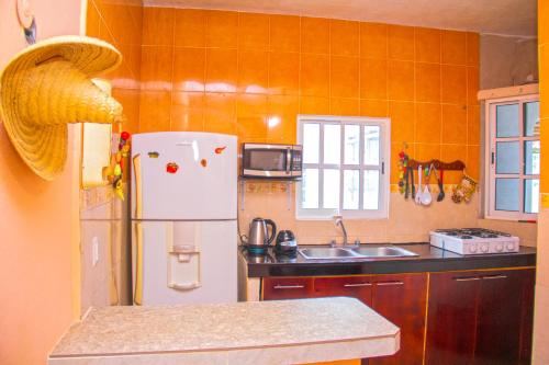 a kitchen with a refrigerator and a sink at Casa Caridad del Cobre in Isla Mujeres