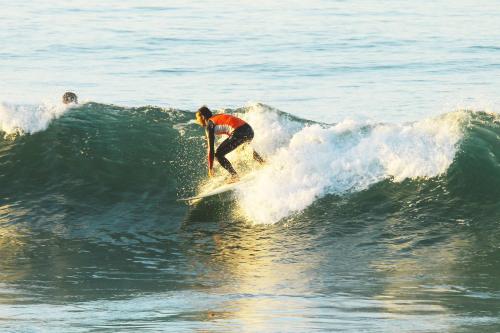 a man riding a wave on a surfboard in the ocean at Original Surf Morocco in Tamraght Ouzdar