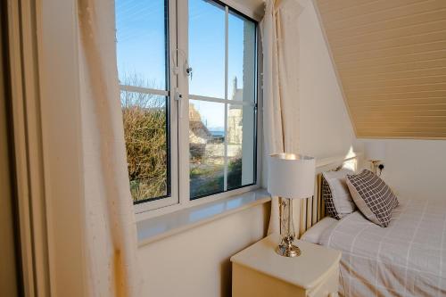 a bedroom with a bed and a window at Bradog House - Beautiful 4 Bedroom House in Central Bundoran in Bundoran