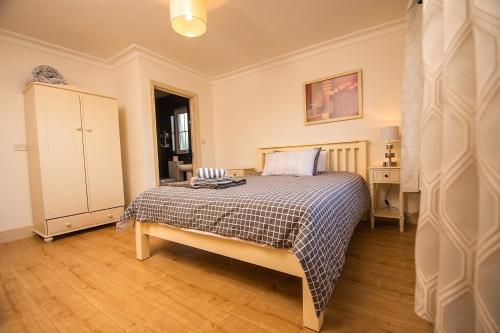 a bedroom with a bed and a dresser in it at Bradog House - Beautiful 4 Bedroom House in Central Bundoran in Bundoran