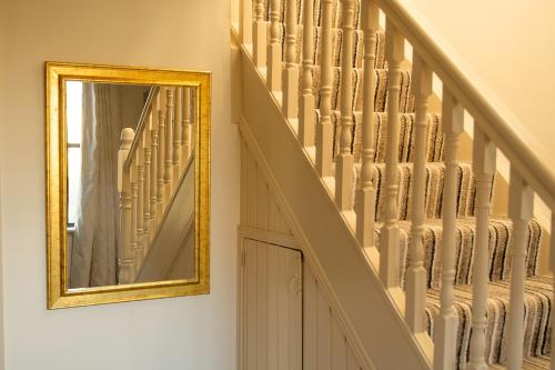 a stairway with a mirror next to a staircase at Bradog House - Beautiful 4 Bedroom House in Central Bundoran in Bundoran