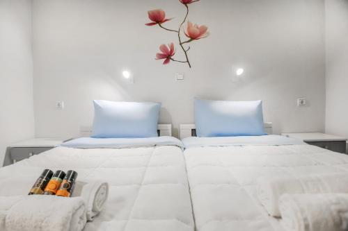 two beds in a room with flowers on the wall at Cormoranos Apartments Rooms Eco Green in Kissamos