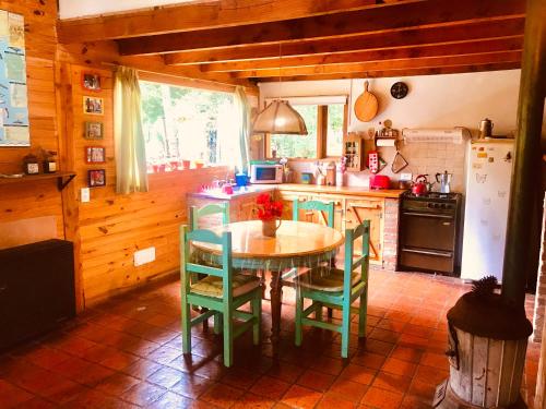 eine Küche mit einem Tisch und Stühlen im Zimmer in der Unterkunft Cabaña de Montaña in San Carlos de Bariloche